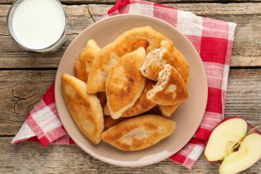 Lezzetli kızarmış pirinçler (doldurulmuş turtalar), tahta masada elma ve süt kesimi, üst manzara