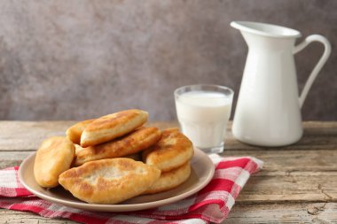 Lezzetli kızarmış pirinçler (doldurulmuş turtalar) ve ahşap masada süt, yakın plan.