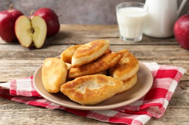 Lezzetli kızarmış pirinçler (doldurulmuş turtalar), süt ve elmalar ahşap masada, yakın plan.