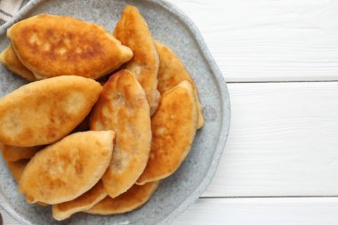 Beyaz ahşap masa üzerinde nefis kızarmış pirizky (doldurulmuş turtalar), üst manzara. Metin için boşluk