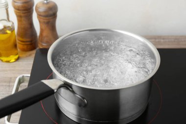 Kaynar suyla tencere ve soba ahşap masa üzerinde beyaz arka plan, yakın çekim