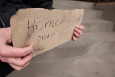 İşaretli adam Evsiz, lütfen dışarıya yardım et, kapat.