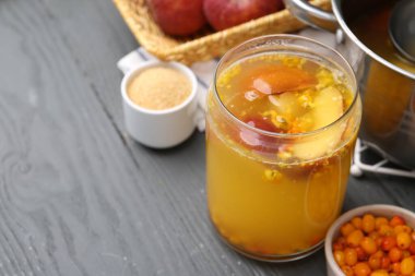 Cam kavanozda lezzetli bir karışım ve gri ahşap masadaki malzemeler, yakın plan. Metin için boşluk