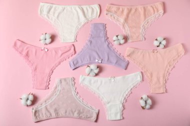 Kadın iç çamaşırı. Pembe arka planda güzel külotlar ve pamuk çiçekleri, düz yatıyordu.
