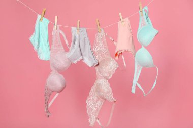 Kadın iç çamaşırı. Güzel iç çamaşırları ve sutyenler pembe arka planda.