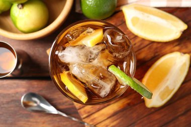 Küba libre kokteyli ve ahşap masa üzerindeki malzemeler tazeleniyor.