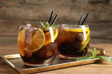 Küba libre kokteylini ahşap masada nane şekeri ile tazeliyorum.