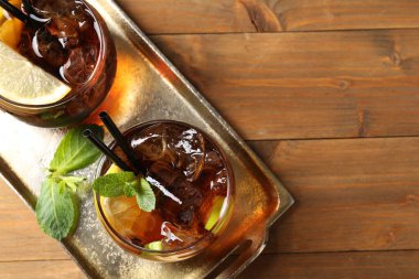 Küba libre kokteylini ahşap masa üzerinde nane şekeri ile tazeliyorum. Metin için boşluk