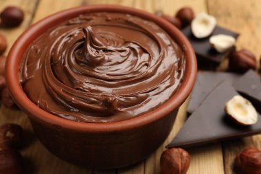 Lezzetli fındık ezmesi, çikolata parçaları ve fındıklar ahşap masada, yakın plan.