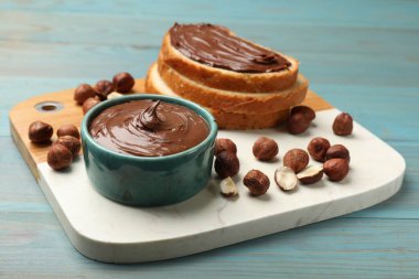 Lezzetli çikolatalı fındıklı tost ve mavi ahşap masada fındıklar, yakın plan.