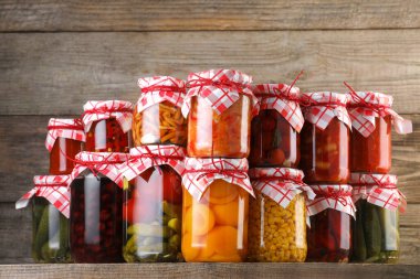 Ahşap masada farklı turşu ürünleri olan bir sürü kavanoz.