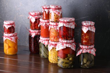 Ahşap masada farklı turşu ürünleri olan bir sürü kavanoz.