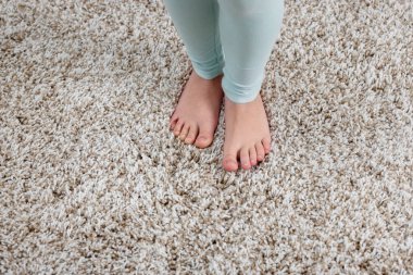 Evdeki yumuşak halıdaki kız, manzaranın üstünde.