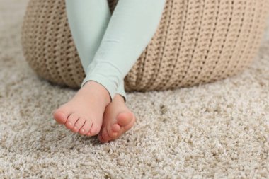 Evdeki yumuşak halıdaki kız, yakın plan.