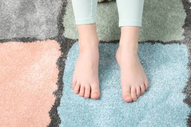 Evdeki yumuşak halıdaki kız, manzaranın üstünde.