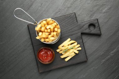 Lezzetli patates kızartması, ketçap ve biberiye ile servis ediliyor.