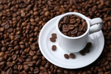 Kahve çekirdekli fincan ve çay tabağı, yakın plan. Metin için boşluk