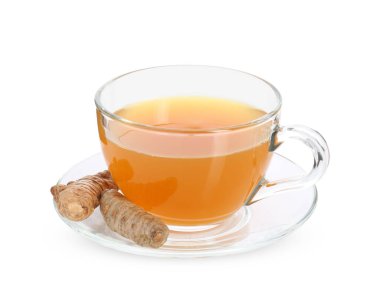 Cam fincanda Aromatik zerdeçal çayı ve beyaz üzerine izole edilmiş kökler.