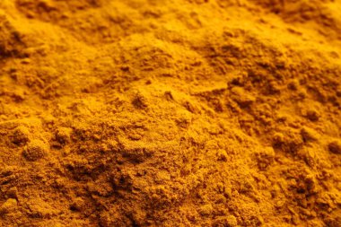 Aromatic turmeric powder as background, closeup view