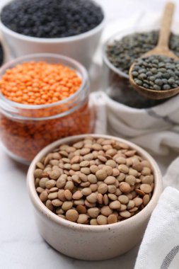 Beyaz masada farklı türde mercimek, yakın plan.
