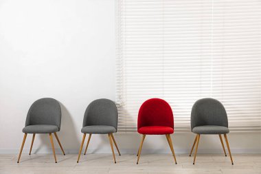 Farklı, eşsiz, özel. Gri olanlar arasında kırmızı sandalye