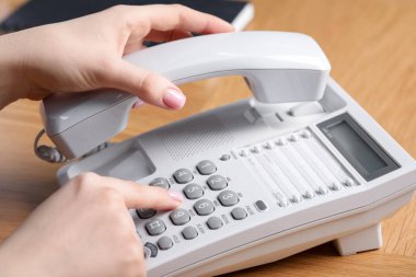 Ahşap masada telefonla arayan kadın, yakın plan.