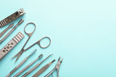 Turkuaz arka planda farklı manikür araçları seti, düz yatış. Metin için boşluk