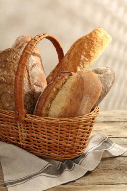 Tahta masadaki sepetin içinde farklı somunlar, yakın çekim.