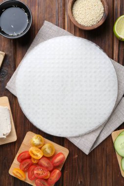 Yenebilir pirinç kağıtları ve malzemeler ahşap masada, düz yerde.