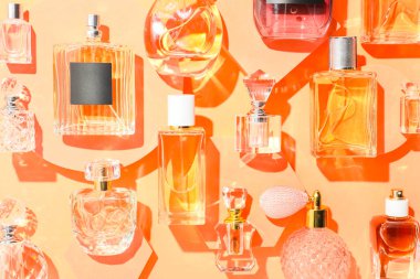 Bej arka planda farklı lüks parfümler, düz yatış