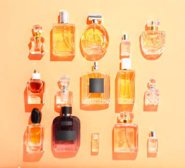 Bej arka planda farklı lüks parfümler, düz yatış