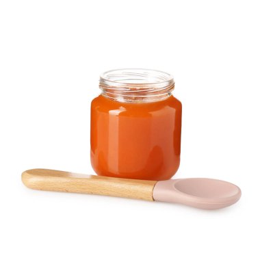 Bebek maması. Cam kavanozda lezzetli püre ve beyaza izole edilmiş kaşık.