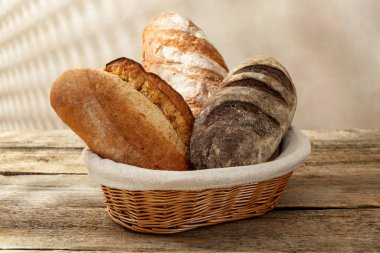 Tahta masadaki sepetin içinde farklı somunlar, yakın çekim.