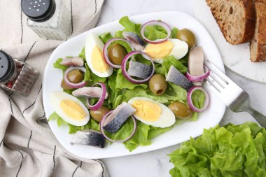 Ringa balıklı lezzetli salata, yumurta ve sebzeler beyaz mermer masada servis edilir, düz konum