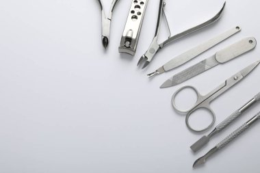 Beyaz arka planda farklı manikür aletleri var. Metin için boşluk