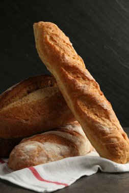 Koyu dokulu masada farklı taze ekmek türleri, yakın çekim.