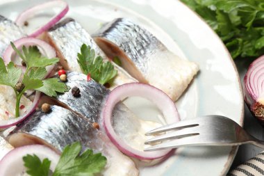 Masada servis edilen baharat ve soğanlı lezzetli ringa balıkları.