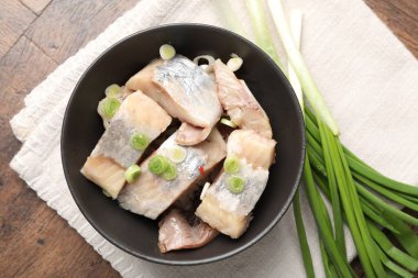 Tahta masada yeşil soğanlı lezzetli ringa balıkları.