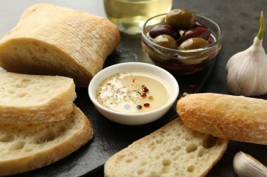 Siyah masada yağlı, zeytinli ve baharatlı dilimlenmiş ekmek, yakın plan.