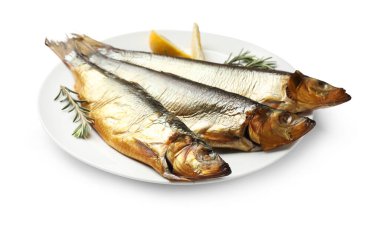 Beyaz arka planda tütsülenmiş ringa balığı, biberiye ve limon