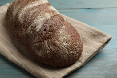 Açık mavi ahşap masada taze ekmek, yakın plan.