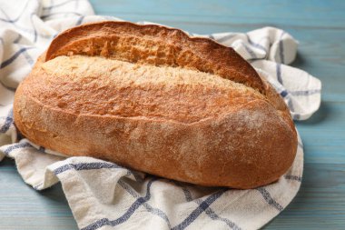 Açık mavi ahşap masada taze ekmek, yakın plan.