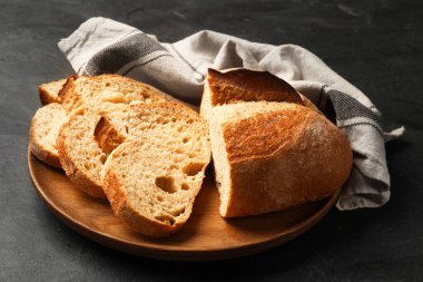 Siyah masanın üzerinde taze ekmek parçaları, yakın plan.