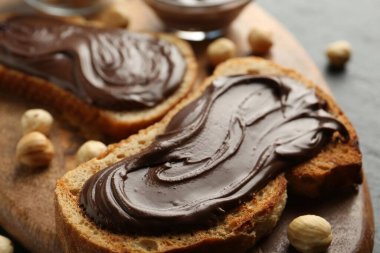 Çikolatalı ekmek dilimleri ve masada fındıklar, yakın plan.