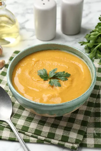 Beyaz mermer masada maydanozlu lezzetli mercimek kremalı çorba.