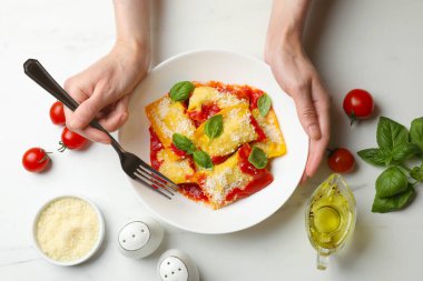 Beyaz masada nefis ravioli yiyen bir kadın.