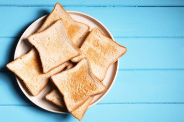 Açık mavi ahşap masa üzerinde lezzetli kızarmış ekmek dilimleri, üst manzara. Metin için boşluk