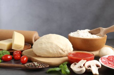 Pizza yapıyorum. Gri masadaki farklı malzemeler, yakın plan.