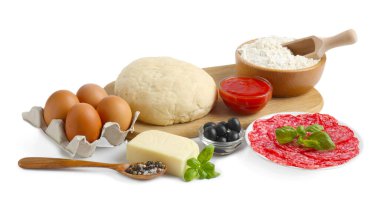 Pizza yapıyorum. Farklı malzemeler beyaza izole edilmiş.