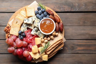 Tahta masa ve üst manzara üzerinde farklı çeşit lezzetli peynir ve diğer atıştırmalıklar. Metin için boşluk